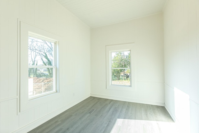 empty room featuring visible vents, baseboards, and wood finished floors