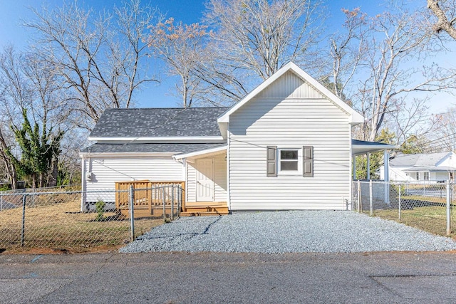 view of front of house with a carport, roof with shingles, and fence