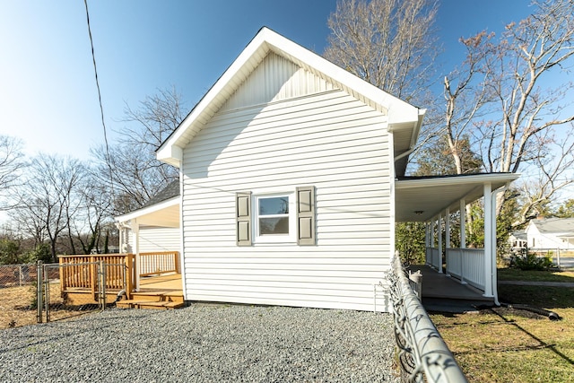 back of house with board and batten siding and a wooden deck