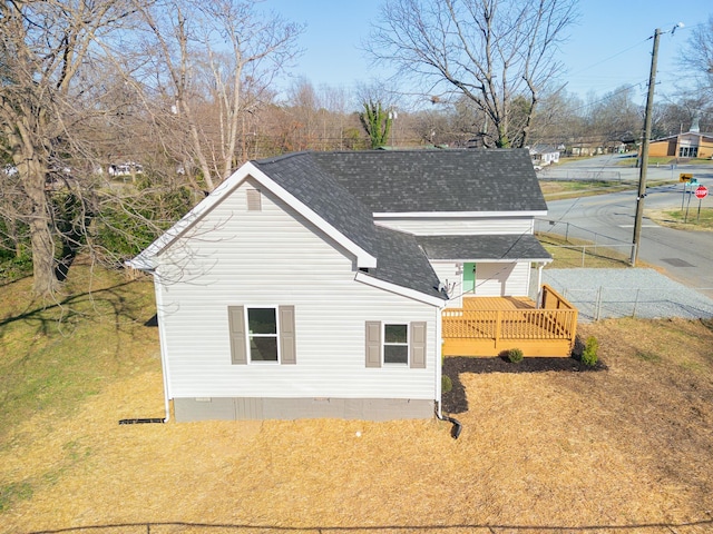 view of side of home featuring crawl space, a deck, and a shingled roof