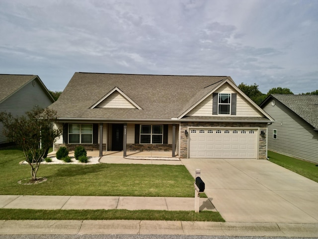 view of front of house featuring a shingled roof, a front lawn, concrete driveway, a garage, and stone siding