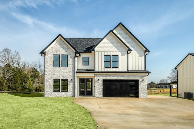 modern farmhouse with a front yard, driveway, a garage, stone siding, and board and batten siding