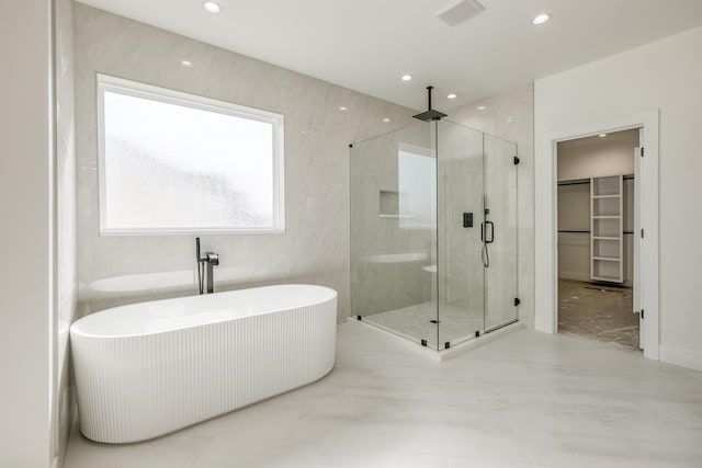 full bathroom with visible vents, a walk in closet, a stall shower, recessed lighting, and a freestanding bath