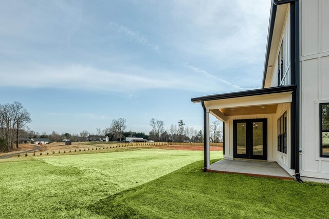 view of yard with a rural view and french doors