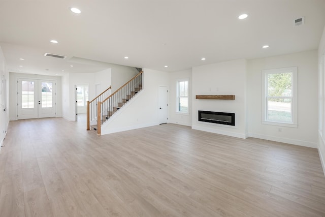 unfurnished living room featuring visible vents, recessed lighting, light wood finished floors, baseboards, and stairs