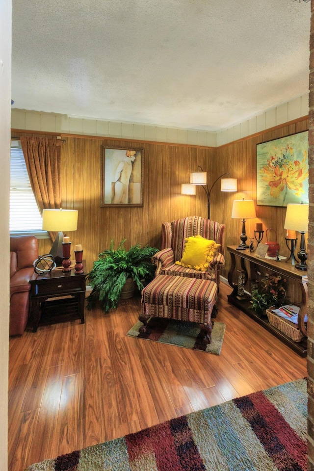 living area with a textured ceiling and wood finished floors