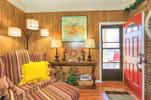 entrance foyer featuring wooden walls, wood finished floors, and brick wall