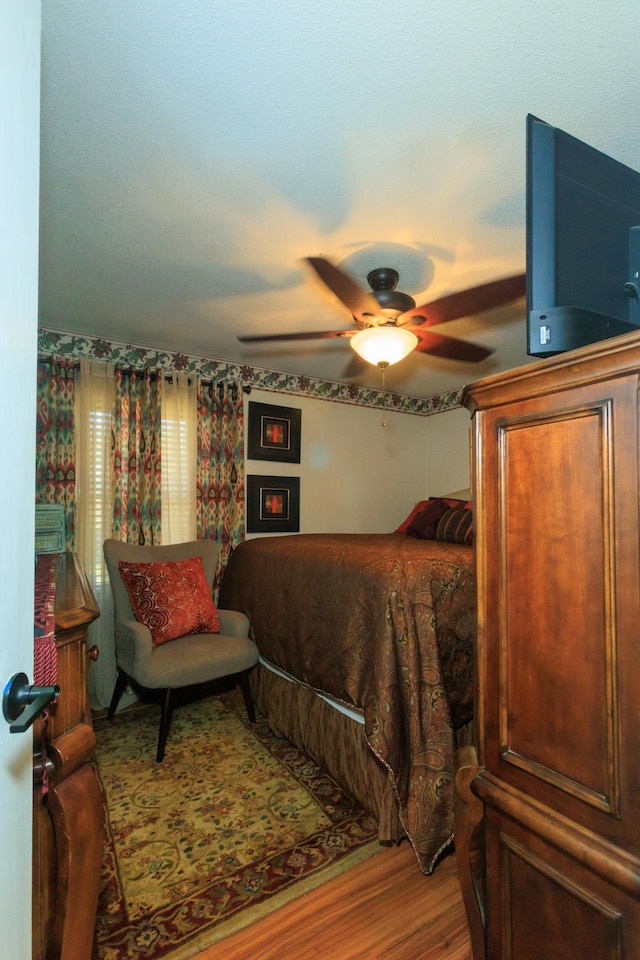 bedroom with a ceiling fan and wood finished floors