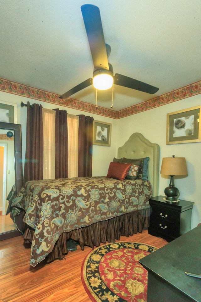 bedroom with ceiling fan and wood finished floors