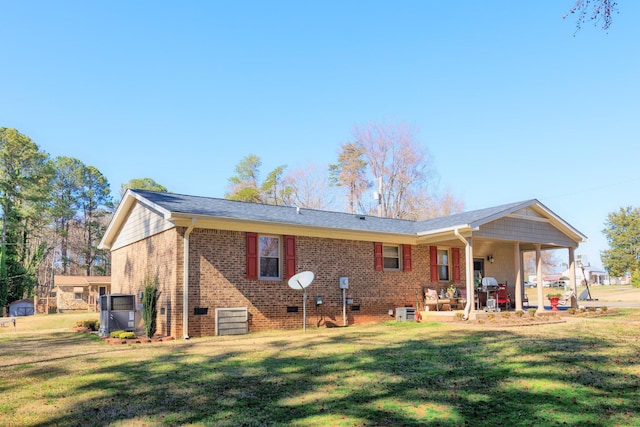 back of house featuring a patio area, a lawn, and brick siding