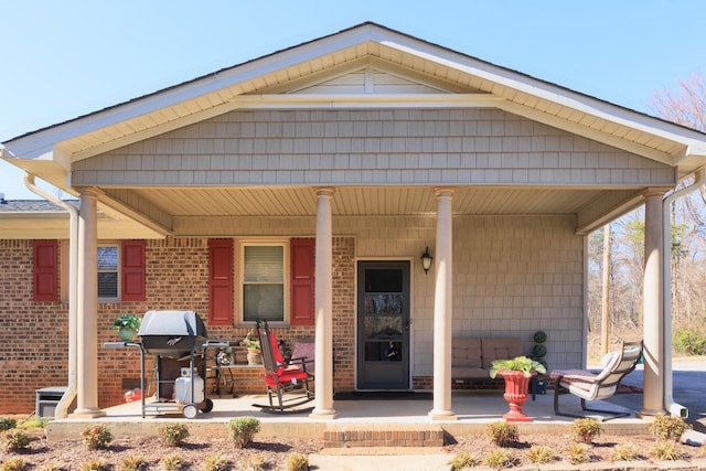 view of front of home featuring brick siding and covered porch