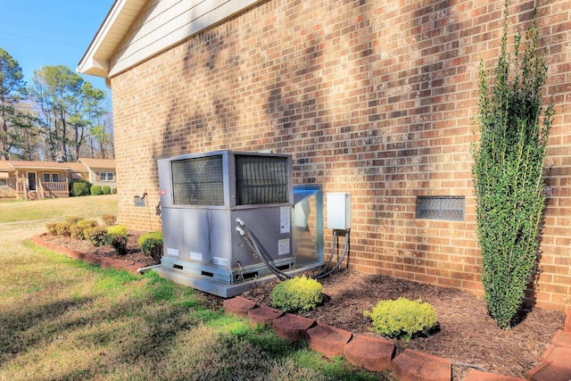 exterior details featuring brick siding and central AC