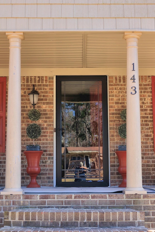 view of exterior entry with brick siding