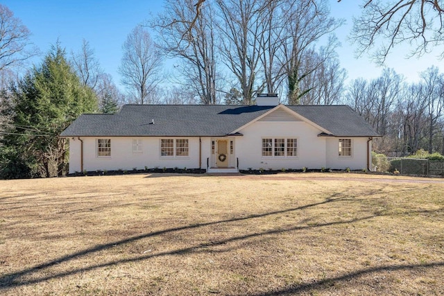 single story home featuring a chimney, a front yard, and fence