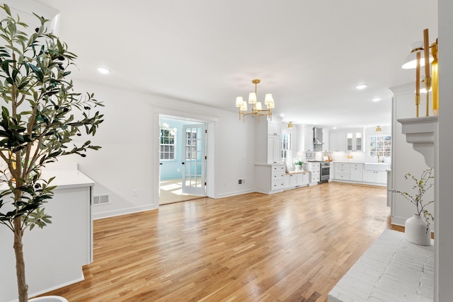 living area featuring recessed lighting, visible vents, light wood finished floors, and a chandelier