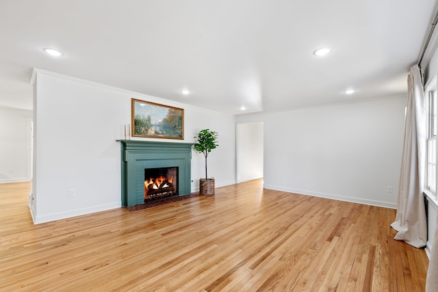 unfurnished living room featuring recessed lighting, baseboards, a brick fireplace, and light wood-style flooring