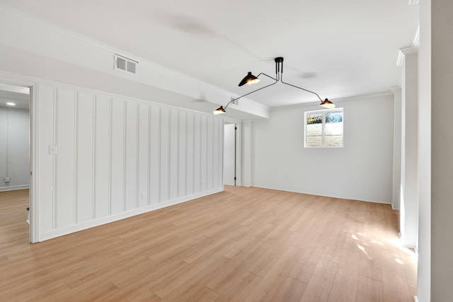 spare room with visible vents, crown molding, and light wood-type flooring