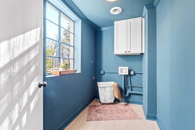 bathroom with visible vents, a healthy amount of sunlight, wood finished floors, and crown molding