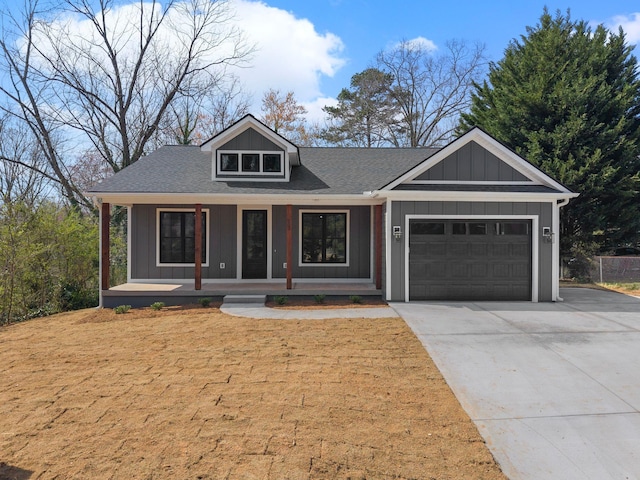 view of front of home with board and batten siding, concrete driveway, an attached garage, and covered porch