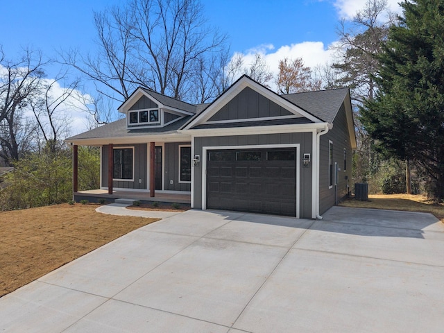 view of front of house featuring cooling unit, a porch, concrete driveway, a garage, and board and batten siding