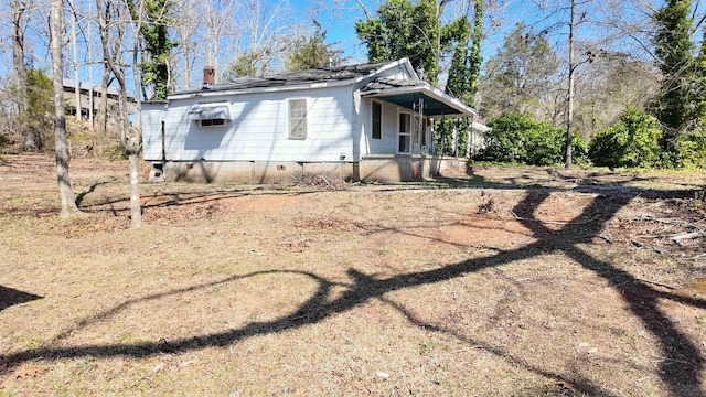 view of side of property featuring crawl space and a chimney