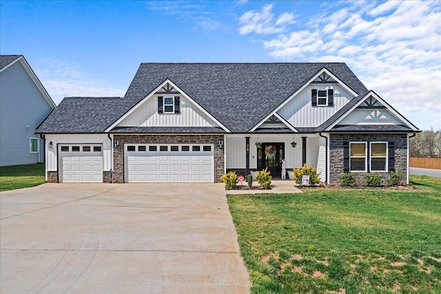 view of front of home featuring board and batten siding, a shingled roof, a front yard, stone siding, and driveway