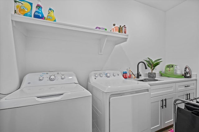 washroom featuring washer and dryer, cabinet space, and a sink