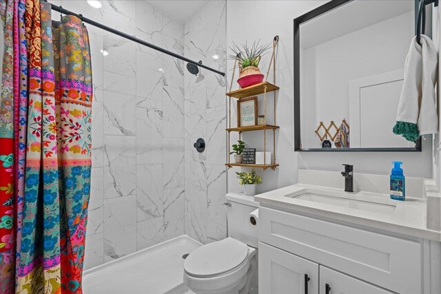 full bathroom with vanity, a shower stall, and toilet