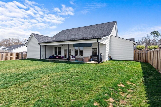 rear view of house featuring a patio, a yard, a ceiling fan, and a fenced backyard