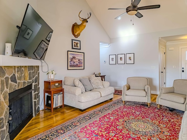 living room with high vaulted ceiling, wood finished floors, a fireplace, baseboards, and ceiling fan