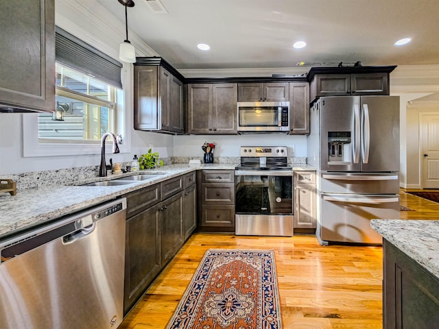 kitchen featuring visible vents, a sink, dark brown cabinetry, appliances with stainless steel finishes, and light stone countertops