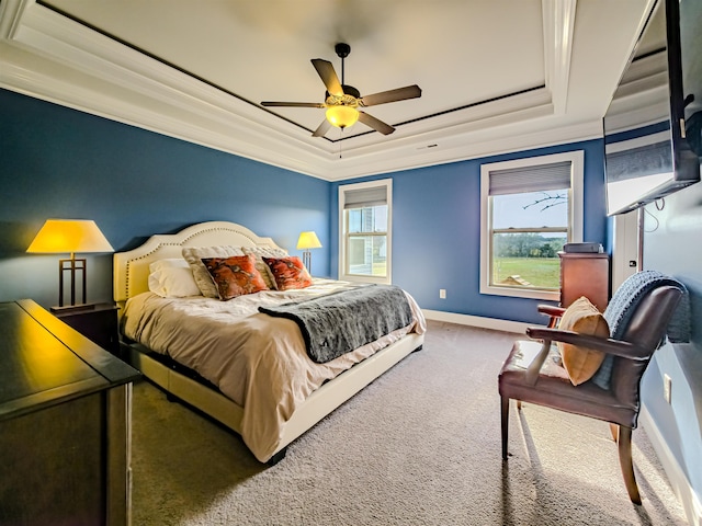 carpeted bedroom with ceiling fan, a tray ceiling, baseboards, and ornamental molding