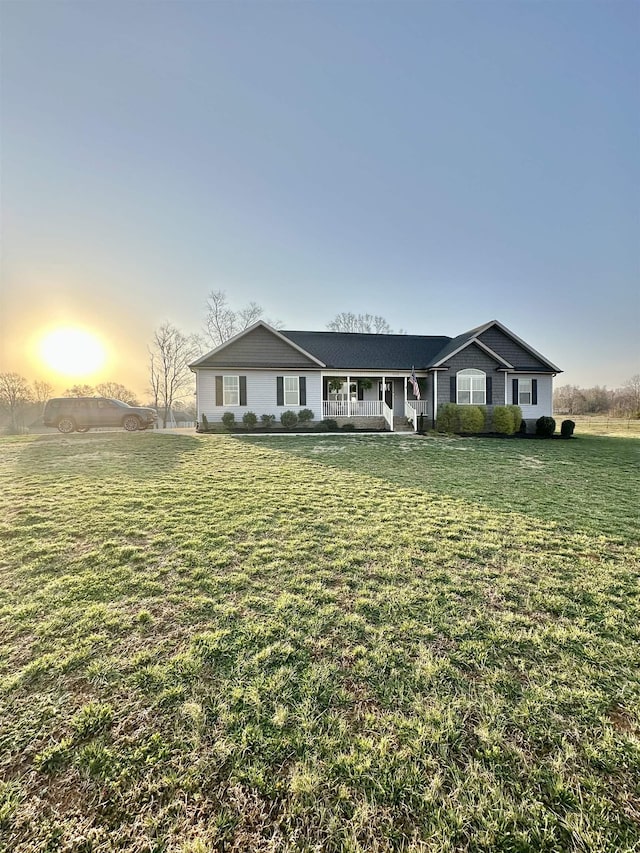 single story home with a porch and a front yard