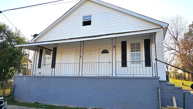 view of front of property with covered porch and fence