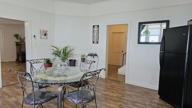 dining space with baseboards and wood finished floors