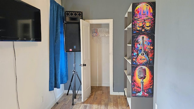 corridor with baseboards and wood finished floors