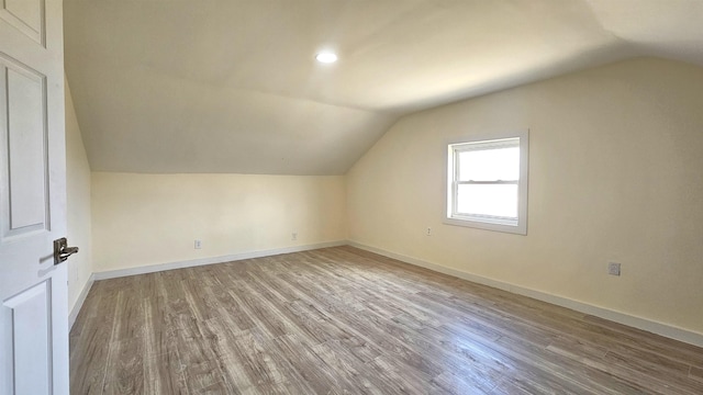 bonus room with vaulted ceiling, wood finished floors, and baseboards