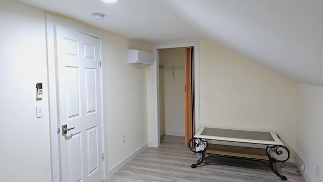 bonus room with light wood finished floors, baseboards, vaulted ceiling, and a wall unit AC