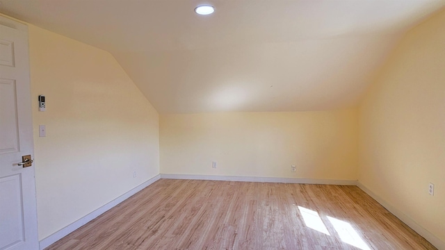 bonus room featuring light wood-style flooring, baseboards, and lofted ceiling
