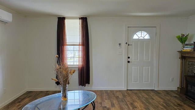 entrance foyer with a fireplace, a wall mounted air conditioner, baseboards, and wood finished floors