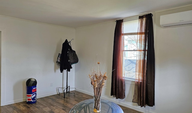 room details featuring a wall mounted air conditioner, baseboards, and wood finished floors