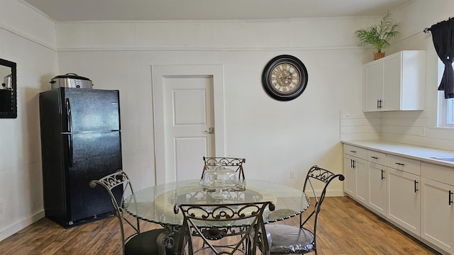 dining space with light wood-type flooring and baseboards