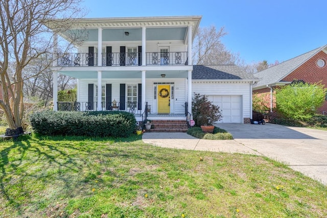 greek revival inspired property featuring a balcony, an attached garage, covered porch, concrete driveway, and a front lawn