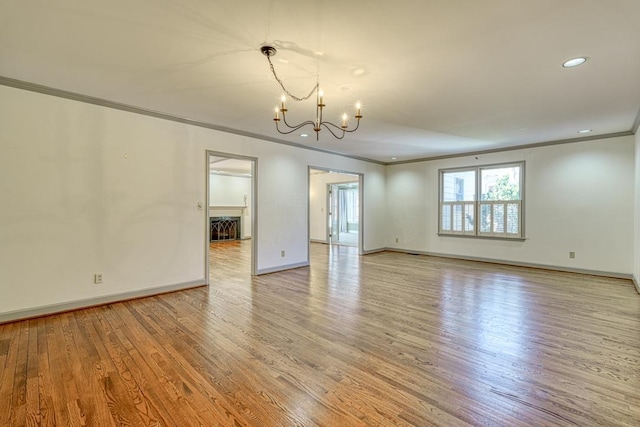 unfurnished room featuring baseboards, recessed lighting, ornamental molding, light wood-style floors, and a notable chandelier