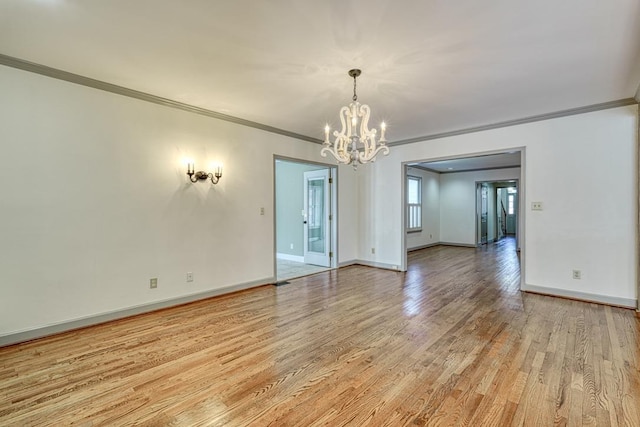 unfurnished room featuring baseboards, light wood-style floors, a chandelier, and crown molding