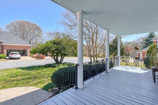 wooden terrace featuring a lawn