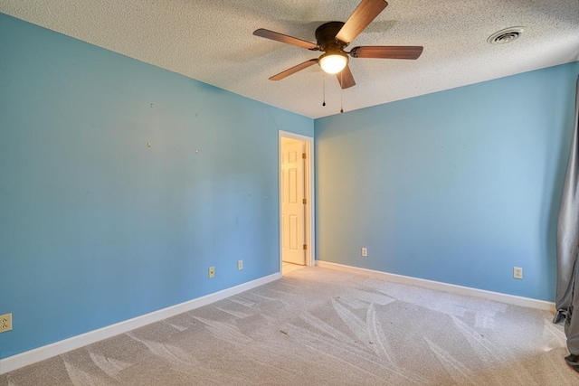 empty room with visible vents, baseboards, carpet flooring, a textured ceiling, and a ceiling fan