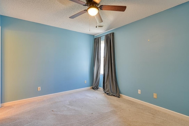 carpeted spare room featuring a ceiling fan, baseboards, and a textured ceiling