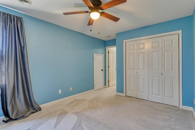 unfurnished bedroom featuring a closet, visible vents, carpet floors, and a textured ceiling