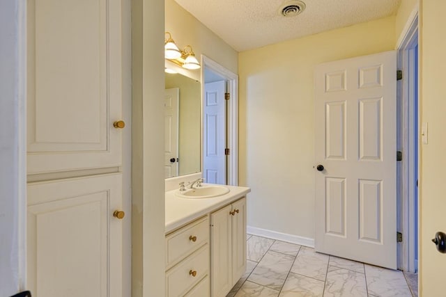 bathroom with vanity, baseboards, visible vents, a textured ceiling, and marble finish floor